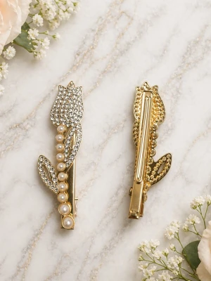 Tulpanformade hårklämmor med pärlor - 1 st eleganta hårklämmor i guldfärgad metall, formade som tulpaner och dekorerade med gnistrande strass och vita pärlor. Perfekt för att ge frisyren en lyxig touch. Klämmorna har en detaljrik design med blad och blomma.