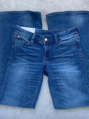 Blå bootcut jeans från Cheap Monday - Säljer ett par skitsnygga blå flare jeans från Cheap Monday med klassisk femficksdesign och gylf med knapp. Jeansen är aldrig använda och har prislapp kvar! Endast testade i butik. Modellen är Flare Low och är i storlek 28/32💗 Köptes för 399 