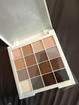 S.KØN ögonskuggspalett Earthbound - Säljer en S.KØN ögonskuggspalett i modellen Earthbound Beauty 01. Paletten innehåller 16 nyanser i jordnära toner som beige, brunt, guld, grått och svart. Färgerna är både matta och skimrande och kommer i en stilren vit plastförpackning. Vegansk och enkel att blanda.