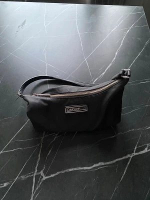 Väska - Väskan är lite sliten på bandet och dragkedjan.