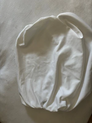 Vit tubtopp med scrunch - En vit tubtopp med scrunch på båda sidor som gör den unik och speciell. Passar till allt och livar upp en outfit på nolltid. 