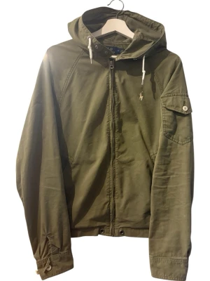 Vintage Ralph lauren vind jacka. - Säljer en snygg och svårhittad grön vindjacka från Polo Ralph Lauren.    Skick: Mycket fint skick överlag. Finns några små diskreta fläckar framtill (syns på bild), men inget som stör helhetsintrycket.  Storlek: S   Denna modell är inte längre i produktion.  Pris kan diskuteras vid snabb affär.