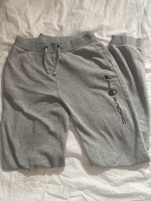 Grå mjukisbyxor från Sail Racing - Snygga grå mjukisbyxor från Sail Racing med logga på benet. 