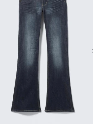Mörkblå bootcut jeans från cheap Monday  - Snygga mörkblå bootcut jeans från cheap Monday med klassisk femficksdesign och coola slitningar på framsidan. Jeansen har utsvängda ben och är tillverkade i denim med en skön stretch. Perfekta för dig som gillar retrostil och vill ha ett statement-plagg. 36/32