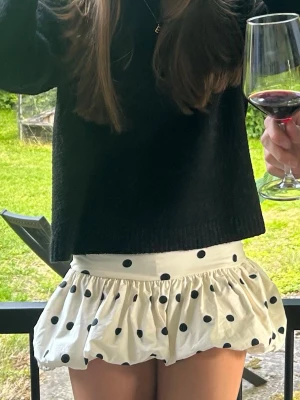 Prickig vit bandeau tubtopp/Kjol - Superfin bandeau tubtopp/kjol i vit med svarta prickar och volangdetalj. Toppen är axelbandslös och har en puffig volang nedtill som ger en unik look🩷