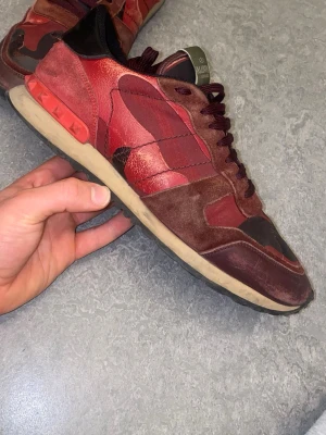 Valentino Rockrunners - Vinröda Valentino Rockrunners med detaljer i både mocka och läder i storlek 43. Lite tecken på användning som visas på de sista två bilderna. Bara att fråga om det är något du undrar över!