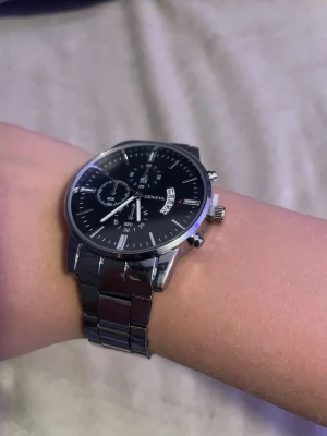 Klocka - En modern silverfärgad klocka som sitter bekvämt på armen, med en omkrets runt 20 cm, och som passar perfekt för både tonåringar och unga vuxna.⭐️⌚️