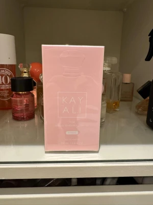 Kayali - Marsmellow  - Kayali Yum är en parfym i en snygg ljusrosa förpackning med minimalistisk design. Flaskan rymmer 100 ml och har en feminin, modern look. Perfekt för dig som gillar söta och fräscha dofter med en lyxig känsla.