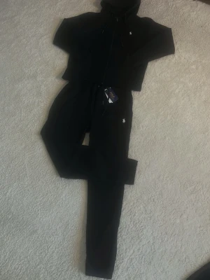 Ralph Lauren tracksuit - Matchande svart tracksuit från Ralph Lauren. Perfekt för både stil och komfort.