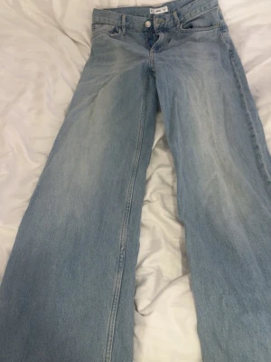 Ljusblåa vida jeans från mango  - Säljer ett par ljusblåa jeans från MNG med rak och vid passform. Jeansen har klassisk femficksdesign, knapp och dragkedja framtill samt snygg tvättad denimlook. Perfekta för en avslappnad och trendig stil.