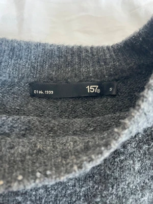 Mörkgrå stickad tröja från 157 - Mysig mörkgrå stickad tröja från 157 med rund halsringning och avslappnad passform. jag gillar inte passformen på mig, skriv ifall frågor eller mer bilder❣️