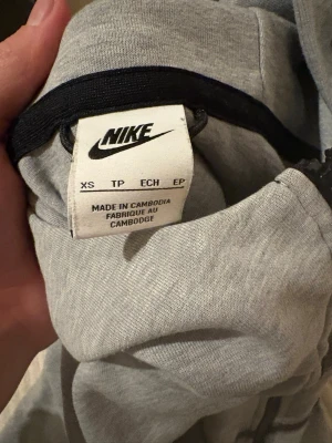 Grå nike tech hoddie  - Säljer min gråa Nike tech hoddie. Saknas band på ena dragkedjan(längst nere) annars är den bra skick. Storlek XS.