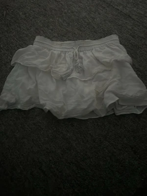 Vita volangshorts med snörning - Hej,jag säljer nu en jättefin volangkjol som är perfekt nu när sommaren börjar närma sig,tveka inte på att höra av dig vid intresse eller frågor!!