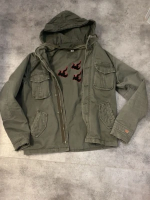 Olivgrön vindjacka med huva - Snygg olivgrön vindjacka. Har haft den länge.