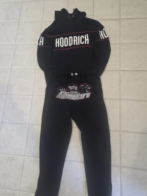 Moose Knuckles jacka riktig fin jacka på vinter svart päls , helt ny Burberry shorts perfekt för sommaren går med simma och ut hoodrich tracksuit blå stiligt hoodrich hoodie med trapstar - Två par mjukisbyxor från Hoodrich, ett par i svart med vitt och rött tryck och ett par i ljusblått med svart och blått tryck. Båda har resår i midjan och tryck på framsidan. Perfekta för chill dagar och streetwear-stil.