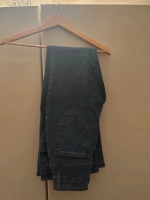 Mörkblå raka jeans - Snygga mörkblå jeans med rak passform och klassiska bakfickor. Perfekta för en avslappnad stil och lätta att matcha med olika toppar. Jeansen har en enkel design utan synliga slitningar eller dekorationer.