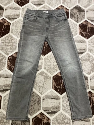 Grå raka jeans från Cubus - Snygga grå jeans från Cubus med raka ben och klassisk femficksmodell. Jeansen har en diskret tvättad look och normal midja. Perfekta till en avslappnad stil och passar till det mesta. Materialet är mjukt denim som ger en bekväm känsla hela dagen.