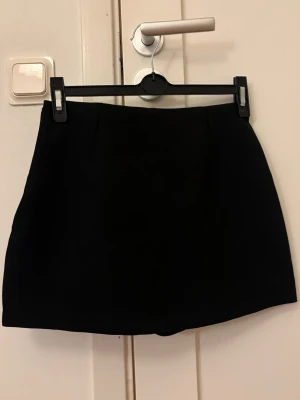 Svart kortkjol - En stilren svart kortkjol med rak passform. 