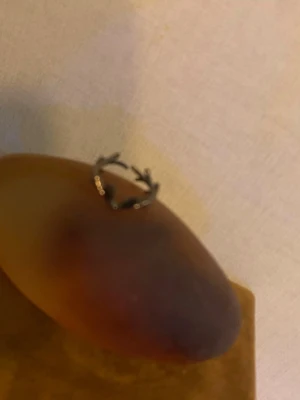 Silvrig ring med grenmönster - Unik silvrig ring i metall med ett coolt grenmönster som ger en naturlig och trendig vibe. Ringen har en öppen design och passar perfekt för dig som gillar naturinspirerade accessoarer. Perfekt att matcha med andra smycken för en personlig stil.