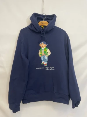 Ralph Lauren beat hoodie - Marinblå polo bear motiv hoodie i mycket mycket bra skick, inga hål eller fläckar. Storleken är M, Unisex. Vid frågor är det bara att fråga😊