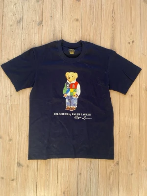 Ralph Lauren polo bear t-shirt - Säljer denna riktigt feta polo bear t-shirt från Ralph Lauren i storlek M och färgen marinblå. Inga tecken på användning och är som ny. Vid andra frågor är det bara komma dm. 