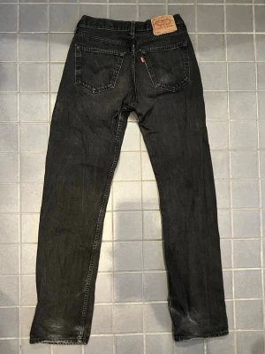 Svarta Levi's 501 jeans straight fit - Sköna levi 501, i princip fläckfria bara lite partiklar/damm på dom. Säljer snabbt skön form, size W31 L34 men passar också större i midja