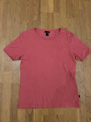 Rosa Tiger of Sweden - strl.M - En enkel rosa t-shirt med rund hals och korta ärmar. Tillverkad i mjuk bomull och har en normal passform. Perfekt till jeans eller shorts för en avslappnad look.