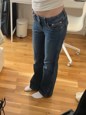 Blå Levi's bootcut jeans low waist  - Säljer ett par klassiska blå Levi's jeans med bootcut passform och låg midja. Jeansen har fem fickor, snygga sömmar och detaljerade bakfickor med knappar. Tillverkade i slitstark denim som ger en tidlös look. Använt ett fåtal gånger 