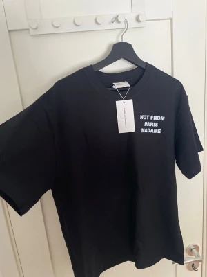 Svart Not From Paris Madame t-shirt - ”Not from Paris madame” från märket Drole de Monsieur. T-shitren är helt ny med etikett och i M , lite oversized look! Nypris ligger på 1299 kr. Skriv vid funderingar!