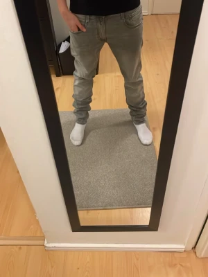 Gråa Replay anbass jeans  - Snygga grå Replay slim fit jeans med klassisk femficksdesign och normal midja. Jeansen har en modern passform som sitter tajt längs benen och är perfekta för en trendig vardagslook. Tillverkade i mjukt denimtyg för skön känsla hela dagen. 