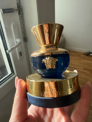 Versace Dylan Blue Pour Femme EdP 30ml - Versace Dylan Blue Pour Femme Eau de Parfum i en lyxig blå och guld flaska med Medusa-detalj. Flaskan är rund med guldfärgat lock och kommer i en elegant blå och guld kartong. Innehåller 30 ml parfym. Provad endast