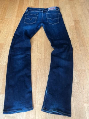 Strait/bootcut diesel jeans - Snygga mörkblå jeans med rak/bootcut passform och klassisk femficksdesign. Jeansen har kontrastsömmar och är tillverkade i ett slitstarkt denimtyg. Perfekta för en clean och enkel look. Modellen är 1985. Priset ärninte higget i sten