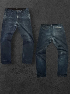 Mörkblå jeans jeans från A.P.C. I straight fit - Säljer ett par mörkblå jeans från A.P.C. med klassisk femficksmodell och raka ben. Jeansen har snygga slitningar och kontrastsömmar för en cool look. Tillverkade i kraftig denim som ger en tidlös och stilren känsla.