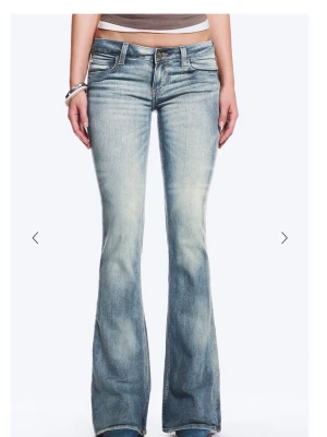 Ljusblå bootcut jeans från Cheap Monday - Säljer ett par ljusblå bootcut jeans från Cheap Monday med snygg slitning och klassisk femficksmodell. Jeansen har låg midja och utsvängda ben, perfekt för en avslappnad och trendig look. Materialet är mjuk denim i bomull med lite stretch.