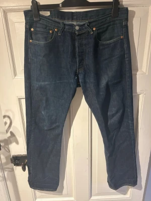 Levi’s 501 - Mörkblåa Levi’s 501 i storlek L30/W32. Ytterbenslängden är 100cm                                            Rak passform Mycket bra skick, utöver en lagning i skrevet.  Skriv vid frågor o h funderingar. Priset är ej hugget i sten! Kolla även min profil för mer!