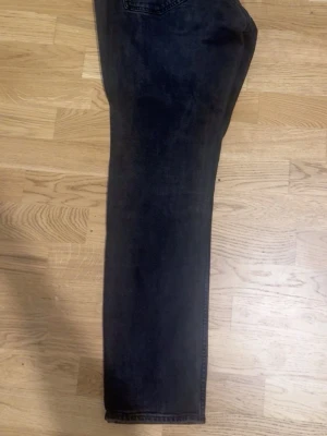 Pull and bear Svarta jeans - Säljer ett par svarta jeans med rak passform och klassisk femficksdesign. Jeansen har en något tvättad look och är tillverkade i denim. Perfekta för dig som gillar en enkel och stilren stil.