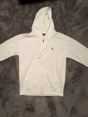 Vit hoodie från Polo Ralph Lauren -  vit hoodie med dragkedja från Polo Ralph Lauren. 