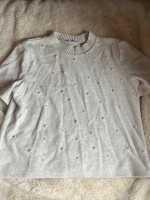 Beige stickad topp med pärldetaljer - Snygg topp med pärlor från Zara. Storlek m men är liten i storlek så den är som en S 