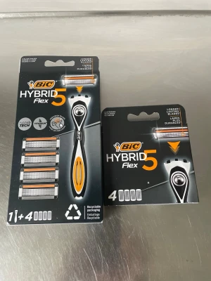 BIC Hybrid Flex 5 rakhyvel & blad - BIC Hybrid Flex 5 rakhyvel med svart och orange handtag samt tillhörande rakblad. Förpackningen innehåller en rakhyvel och totalt åtta utbytbara blad. Nanotech och titaniumbeläggning för extra hållbarhet. Förpackningarna är återvinningsbara.Tillsammans 8 blad 