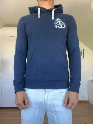 Mörkblå hoodie  - Mörkblå hoodie från Stanley/Stella. Strl S. Inga defekter. Hoodien är tillverkad i 100% bomull. Modellen är 178 cm och väger 77 kg. Hör gärna av dig vid frågor!