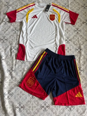 Spanien fotbollskit Adidas herr - Spanien fotbollsträningsset i storlek S. Shortsen har fickor med dragkedjor. Helt nya och oanvända, Hör gärna av vid frågor!