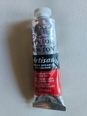 Winsor & Newton Artisan oljefärg röd - Tub med vattenblandbar oljefärg från Winsor & Newton, Artisan-serien. Färgen är Cadmium Red Deep Hue och tuben är i metall med röd och silverfärgad design. Perfekt för konstnärer som vill måla med olja men ändå kunna använda vatten.