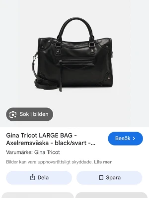 Svart handväska från Gina Tricot - Stilren svart handväska i konstläder från Gina Tricot med både handtag och avtagbar axelrem. Väskan har silverfärgade detaljer, en dragkedjeficka framtill och dekorativa nitar i hörnen. Perfekt för dig som gillar en edgy och modern look.