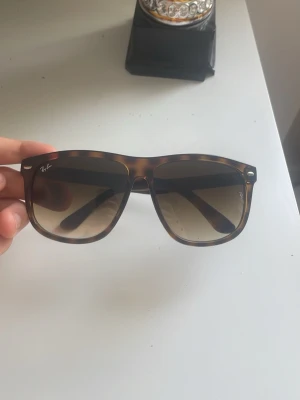 Ray-Ban boyfriends - Snygga Wayfarer solglasögon från Ray-Ban med brunmelerad båge och mörka tonade glas. Klassisk fyrkantig form och diskret Ray-Ban-logga på båda sidor. Perfekta för soliga dagar och ger en cool vibe till din outfit.