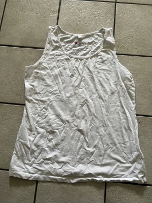 Vit linnetopp från bpc bonprix storlek L - Klassisk vit linnetopp från bpc bonprix collection. Enkel och stilren design med rund halsringning och ärmlös modell. Perfekt att matcha med jeans eller shorts. Tillverkad i mjuk bomull för en bekväm känsla.