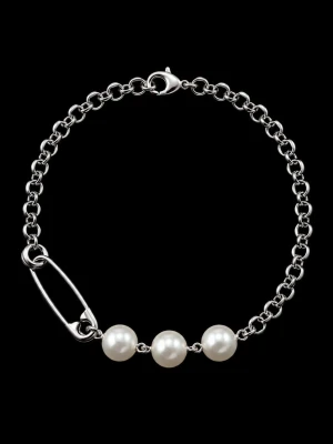 Silverfärgat armband med pärlor - Stilrent armband i silverfärgad metall med en kedja och tre vita pärlor. Armbandet har en unik detalj med en säkerhetsnål som ger en cool kontrast till de klassiska pärlorna. Perfekt accessoar för dig som gillar att mixa stilar.