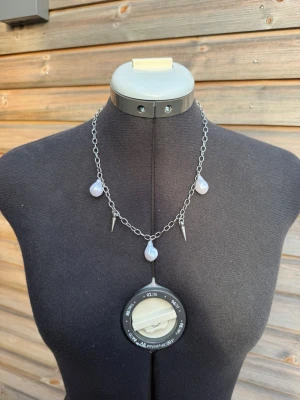 Kedjehalsband med pärlor och spikes - Snyggt halsband med silverfärgad kedja, dekorerat med tre vita pärlor och tre metallspikar som ger en cool kontrast. Perfekt accessoar för dig som gillar att sticka ut med detaljer och mixa olika stilar.