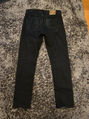 Nudie gritty Jackson  - Hej jag säljer mina nudie gritty Jackson som är mörkblå. De har snygga fades på bakfickorna och lite där framme. De sitter väldigt bra och är i storlek 30 x 32. Hör av er om ni har några frågor 