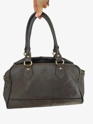 Mörkbrun handväska i läder🌸 - Stilren mörkbrun handväska från Polo Ralph Lauren i äkta läder. Väskan har två rejäla handtag, guldfärgade metalldetaljer och en klassisk, mjukt rundad form. Perfekt för dig som gillar tidlös design och vill ha plats för det viktigaste.