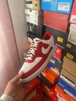 Nike Court Vision Low sneakers röd/vit EUR 45 - Nike  Low sneakers i rött och vitt med klassisk siluett. Ovandel i läder med perforerad tåbox för ventilation, vit sula och röda detaljer. Ikonisk Swoosh-logga på sidorna och vita skosnören. Perfekt för dig som gillar streetwear och sportig stil.